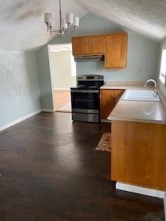 kitchen featuring stainless steel range with electric stovetop, sink, vaulted ceiling, a textured ceiling, and kitchen peninsula