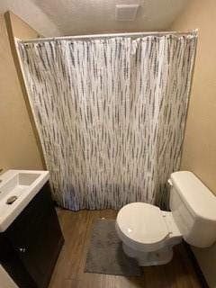 bathroom featuring hardwood / wood-style flooring, vanity, curtained shower, and toilet