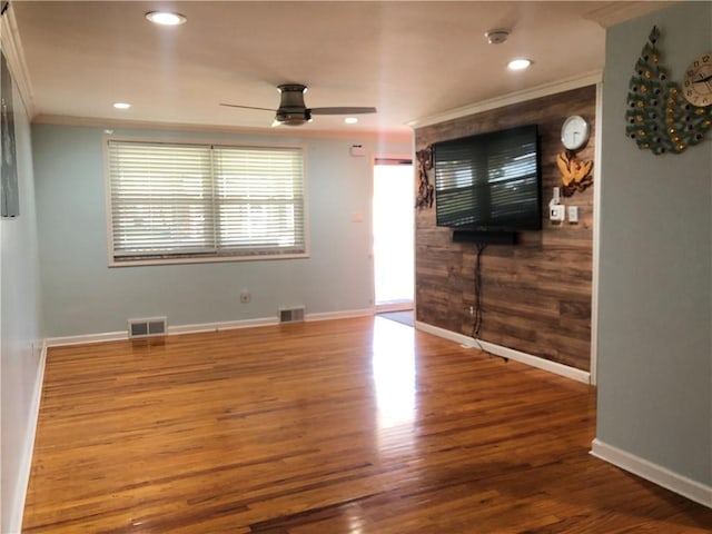 unfurnished living room with wood-type flooring, ceiling fan, and crown molding