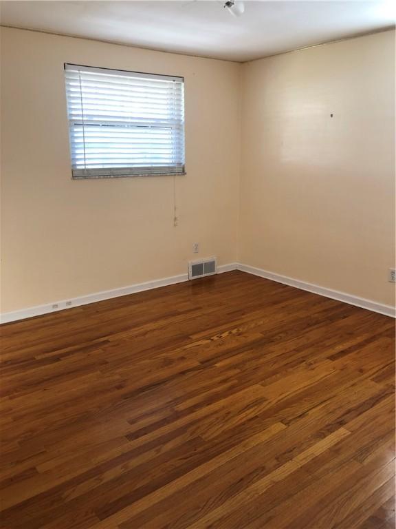 unfurnished room featuring dark wood-type flooring