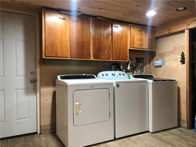 laundry room with cabinets, washing machine and dryer, light hardwood / wood-style floors, and wooden ceiling