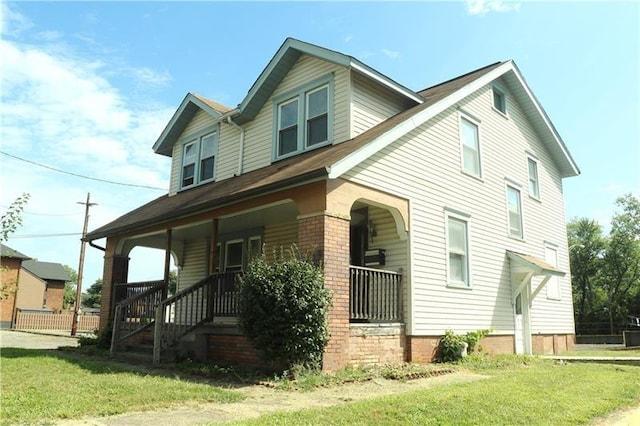 view of front of house featuring covered porch and a front yard