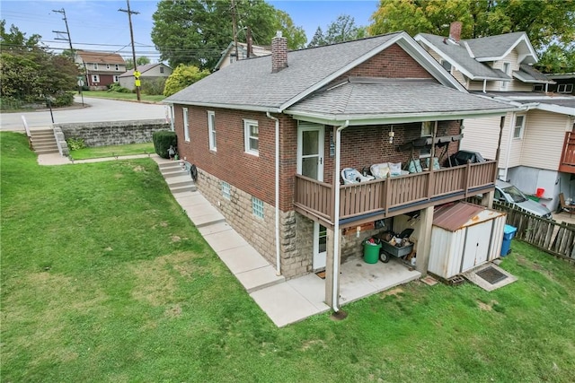 exterior space featuring a storage unit, a yard, and a wooden deck