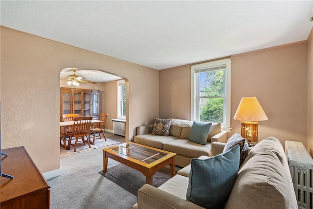 living room with ceiling fan, radiator heating unit, and carpet floors