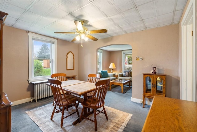 dining area with a healthy amount of sunlight, ceiling fan, and dark carpet