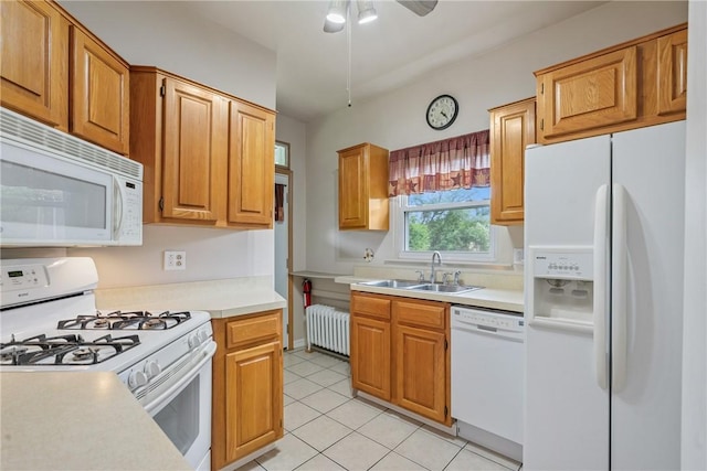 kitchen featuring ceiling fan, radiator heating unit, sink, white appliances, and light tile patterned floors