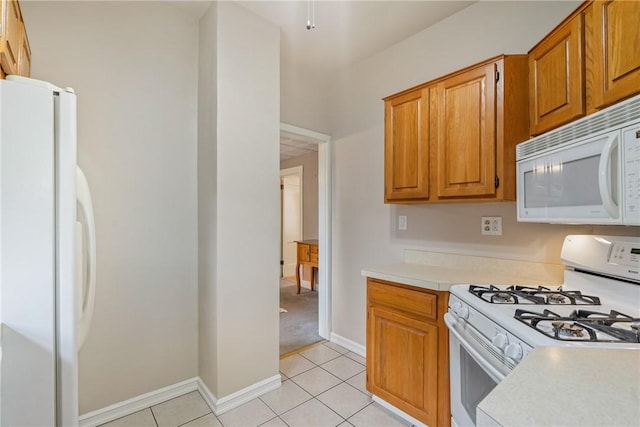 kitchen with light tile patterned flooring and white appliances