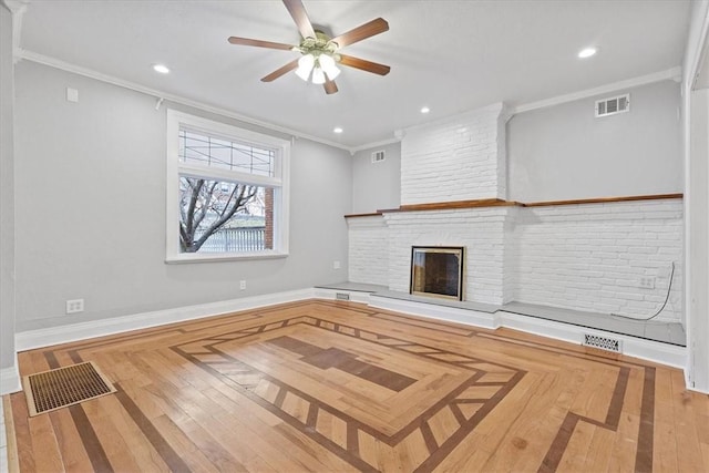 unfurnished living room with crown molding, ceiling fan, wood-type flooring, and a brick fireplace