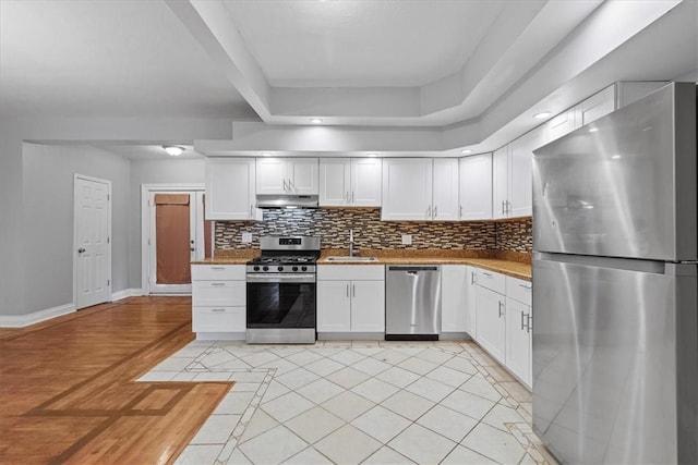 kitchen featuring white cabinets, light tile patterned floors, stainless steel appliances, and sink