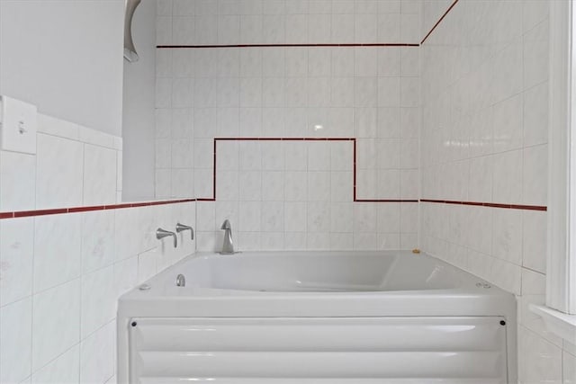 bathroom with a bath and tile walls