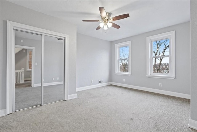 unfurnished bedroom with light colored carpet and ceiling fan