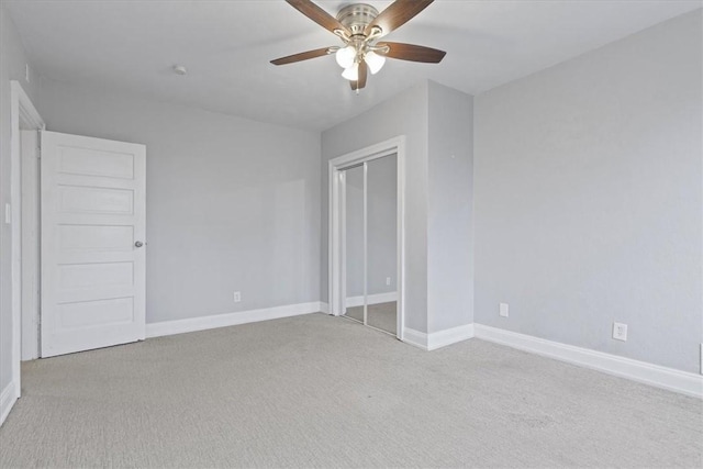 unfurnished bedroom featuring ceiling fan, light carpet, and a closet