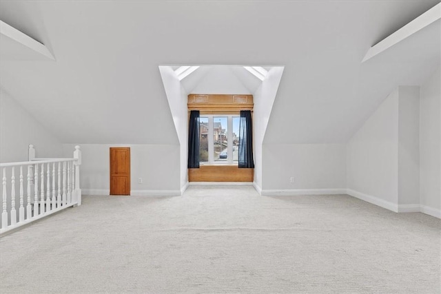 additional living space with light colored carpet and vaulted ceiling