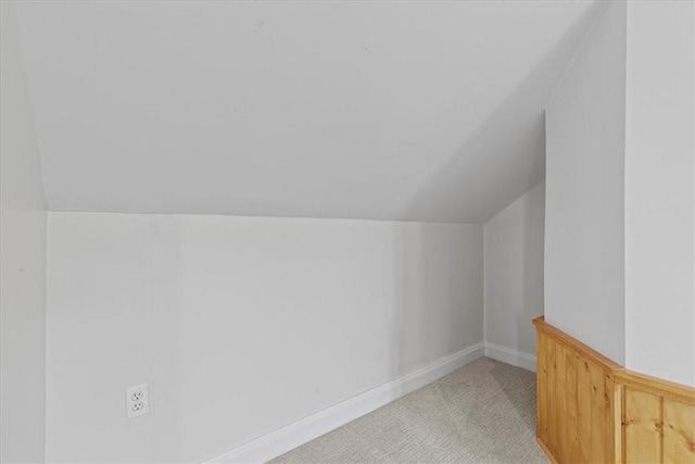 bonus room with lofted ceiling and light carpet