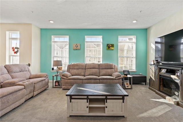 living room with a textured ceiling and light carpet