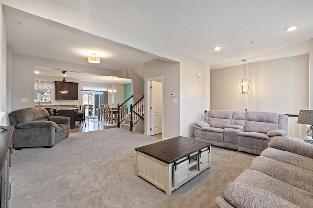 carpeted living room featuring an inviting chandelier