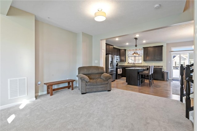 carpeted living room featuring sink