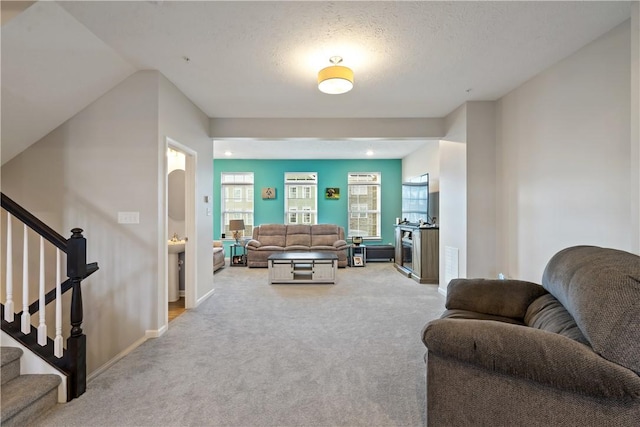 carpeted living room featuring a textured ceiling