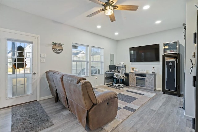 living room with plenty of natural light, ceiling fan, and light wood-type flooring