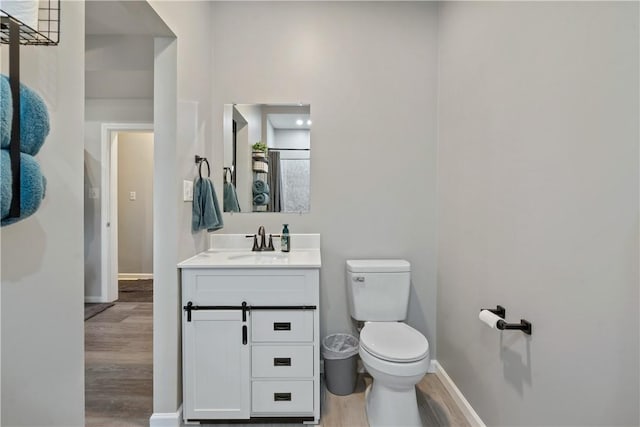 bathroom featuring vanity, hardwood / wood-style flooring, and toilet