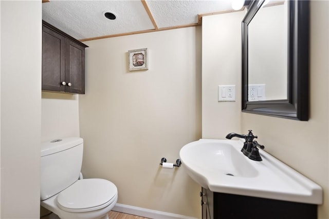 bathroom with crown molding, toilet, a textured ceiling, and vanity