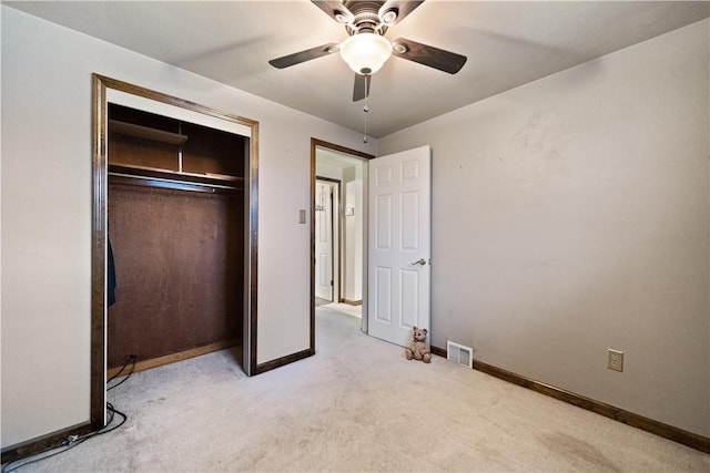 unfurnished bedroom featuring ceiling fan, light carpet, and a closet