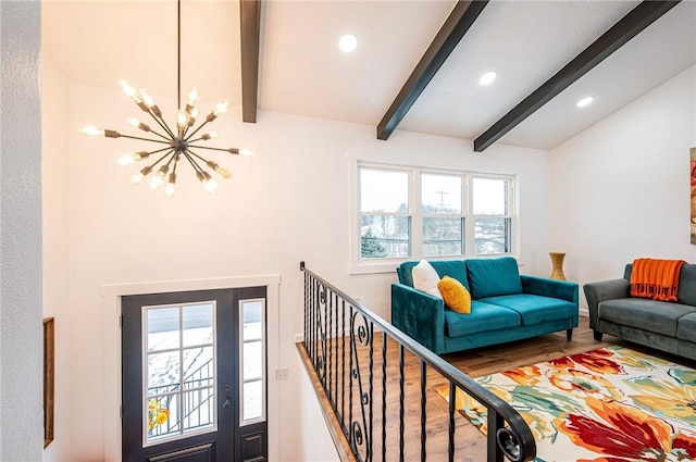 living room with beamed ceiling, a chandelier, and wood-type flooring