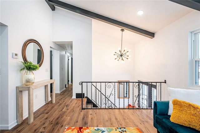 hallway with lofted ceiling with beams, hardwood / wood-style flooring, and a notable chandelier