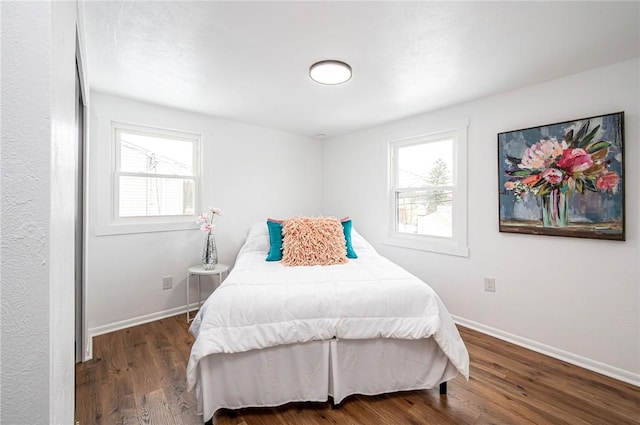 bedroom featuring multiple windows and dark wood-type flooring