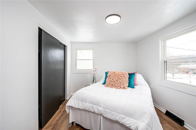 bedroom with dark wood-type flooring