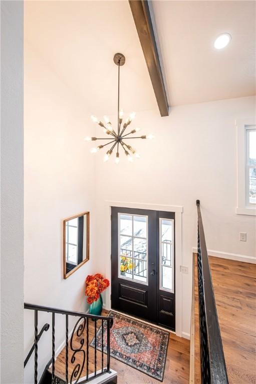 foyer with beamed ceiling, a chandelier, and hardwood / wood-style flooring