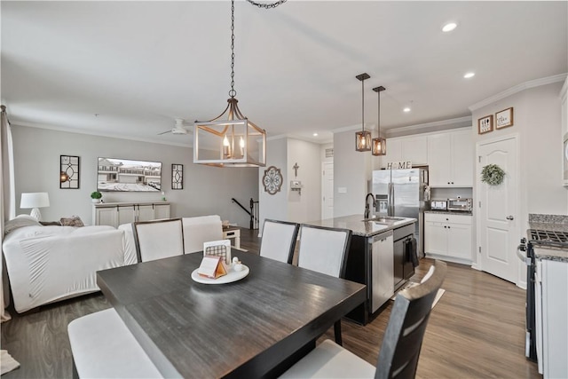 dining area featuring hardwood / wood-style floors, ceiling fan, sink, and crown molding