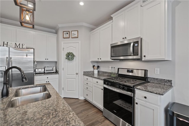 kitchen featuring dark stone counters, sink, white cabinets, and stainless steel appliances