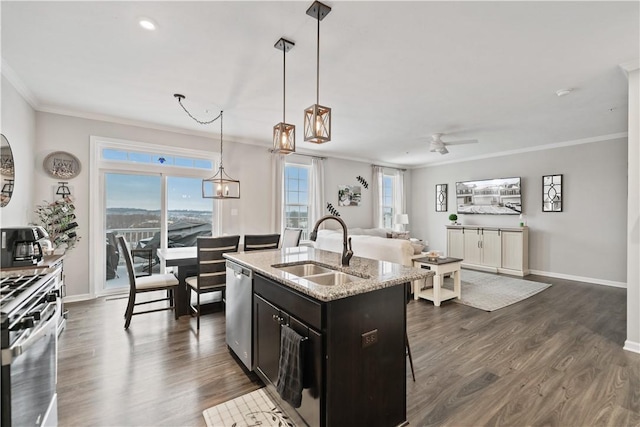 kitchen featuring sink, an island with sink, pendant lighting, appliances with stainless steel finishes, and ornamental molding