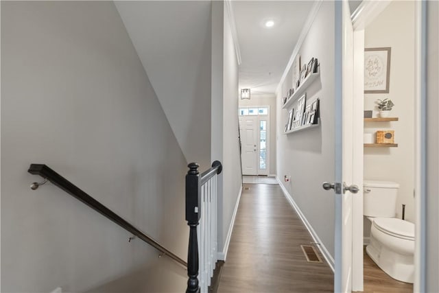 staircase with hardwood / wood-style floors and crown molding