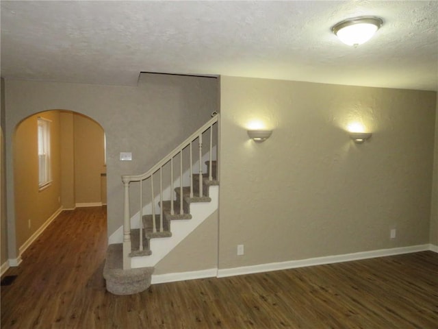 stairs featuring wood-type flooring and a textured ceiling