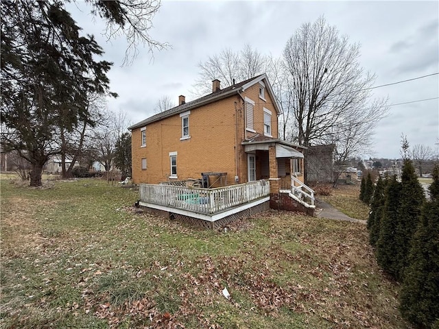 back of house featuring a lawn and a wooden deck