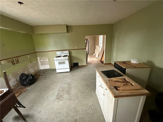 kitchen featuring white cabinets and gas range gas stove