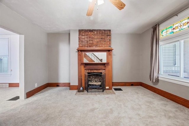 unfurnished living room featuring a fireplace, light carpet, and ceiling fan