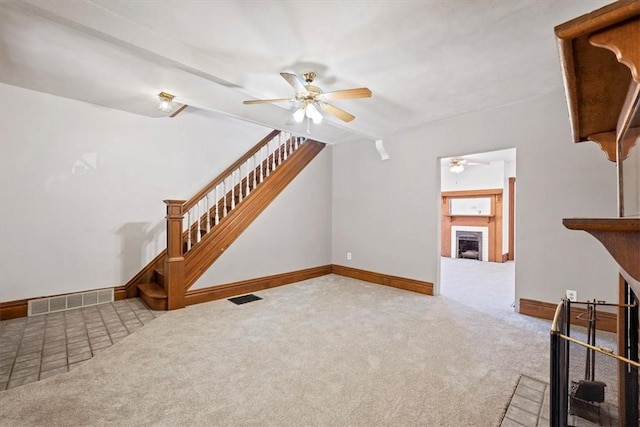 unfurnished living room featuring ceiling fan and carpet floors