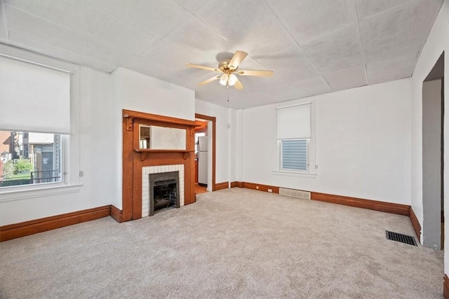 unfurnished living room with carpet, ceiling fan, and a fireplace