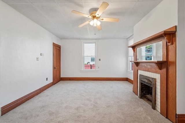 unfurnished living room featuring ceiling fan, light colored carpet, and a brick fireplace