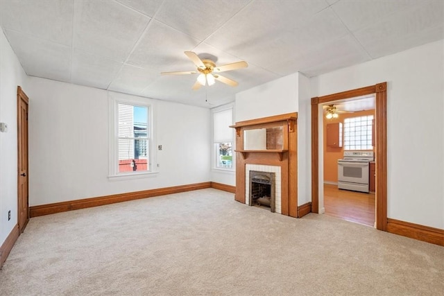 unfurnished living room with carpet, a fireplace, and ceiling fan