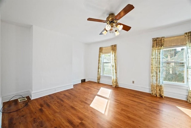 empty room with ceiling fan, hardwood / wood-style floors, and plenty of natural light