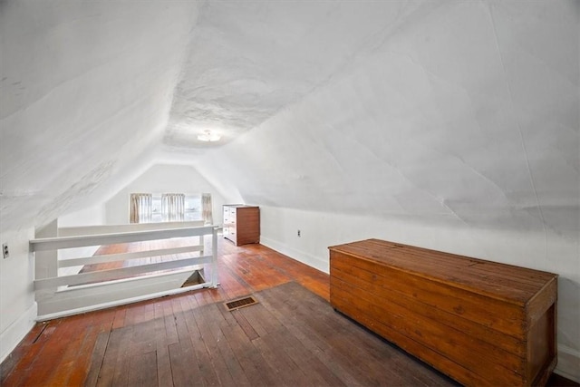 additional living space featuring hardwood / wood-style flooring and vaulted ceiling