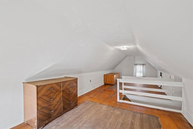 additional living space featuring lofted ceiling and hardwood / wood-style flooring