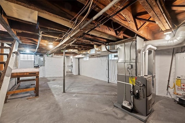 basement with electric panel, gas water heater, and heating unit