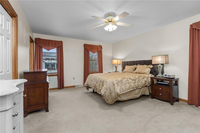 bedroom featuring light colored carpet and ceiling fan