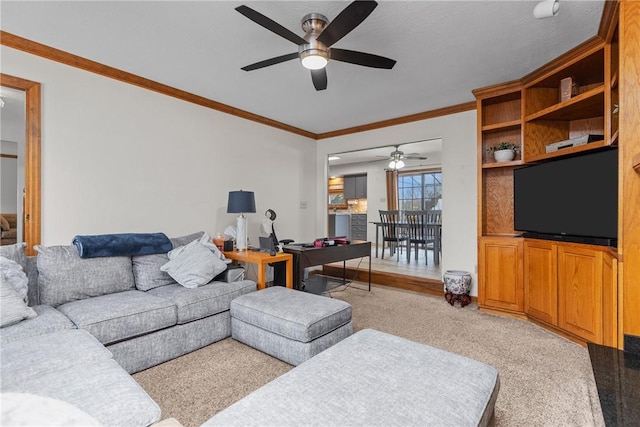 carpeted living room with ceiling fan and ornamental molding