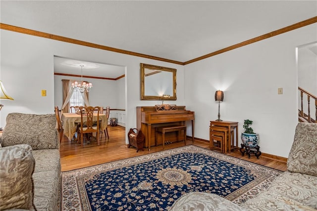 living room featuring wood-type flooring, an inviting chandelier, and crown molding